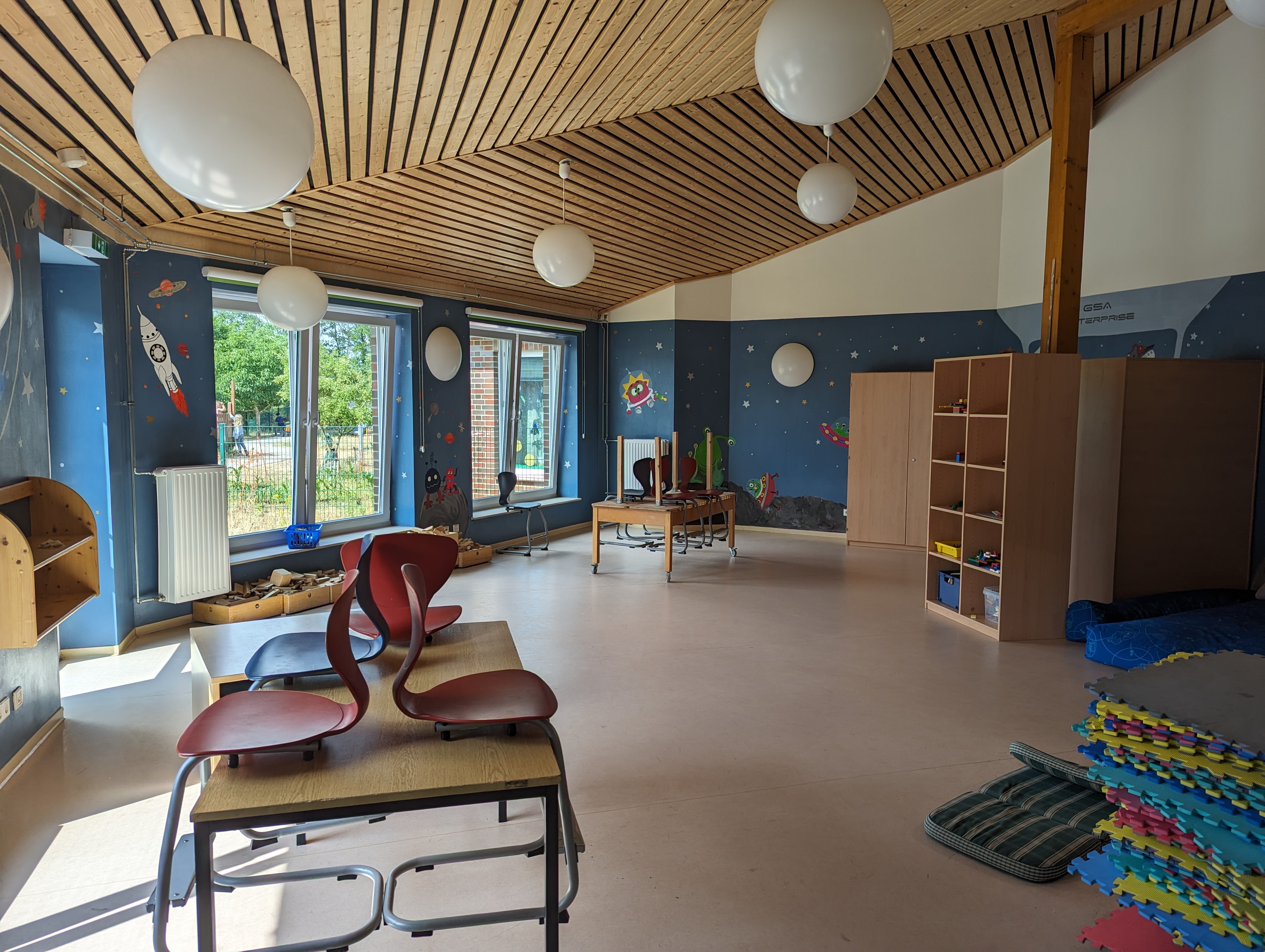 Bauraum im Ganztag der Grundschule Ashausen mit weltraumgestalteten Wänden und Bereichen zum Bauen und Spielen.